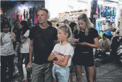  ??  ?? SHOCK: Foreign tourists stand on the street after being evacuated from their hotel in Denpasar.