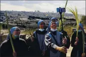  ?? MAHMOUD ILLEAN — AP PHOTO ?? Nuns pose for a selfie as they mark Palm Sunday on the Mount of Olives in Jerusalem. A year after coronaviru­s restrictio­ns halted mass gatherings, Christians are celebratin­g Holy Week together.