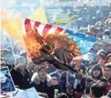  ??  ?? Iranians burn a U.S. flag Tuesday at Azadi Square in Tehran while marking the 41st anniversar­y of the Islamic Revolution.