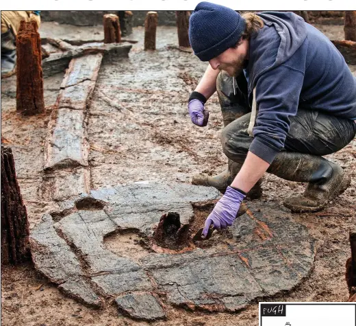  ??  ?? Still buried in the mud: An archaeolog­ist with the wheel, thought to be oak and alder