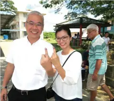  ??  ?? Teng Ung Woo and wife show their inked fingers after exercising their voting rights.
