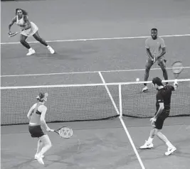  ?? TREVOR COLLENS/AP ?? Roger Federer, bottom with partner Belinda Bencic, returns a shot Tuesday during a mixed doubles match against Frances Tiafoe and Serena Williams at the Hopman Cup.