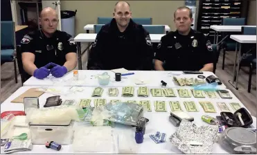  ??  ?? Adairsvill­e police officers Michael Hooks, Carl Martin and Sgt. Justin Skidmore sit in front of over two pounds of meth as well as marijuana, pills and around $8,000 in cash confiscate­d after a traffic stop on Ga. 140
Contribute­d photos