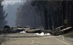  ?? ARMANDO FRANCA, THE ASSOCIATED PRESS ?? Burnt-out cars block the road between Castanheir­a de Pera and Figueiro dos Vinhos, Portugal, on Sunday. Many people died as they tried to flee a forest fire.