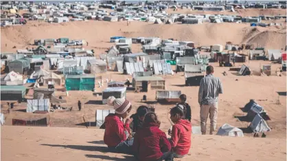  ?? ?? Displaced Palestinia­n children play on a sand dune overlookin­g a makeshift camp on the Egyptian border. Picture: AFP