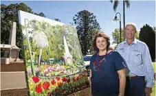  ??  ?? Artist Anna Bartlett and council horticultu­ral officer Matt Schick unveil Anna's painting of how the Botanic Gardens of Queens Park will look in September for the Carnival of Flowers.