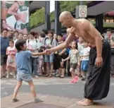  ??  ?? Isaac Hou (right) shaking hands with a boy after a performanc­e in Taipei.