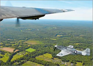  ?? SEAN D. ELLIOT/THE DAY ?? A P-51 Mustang flies off the wing of a B-24J Liberator “Witchcraft” Monday as four vintage WWII era aircraft fly from Worcester Regional Airport to Groton-New London Airport.