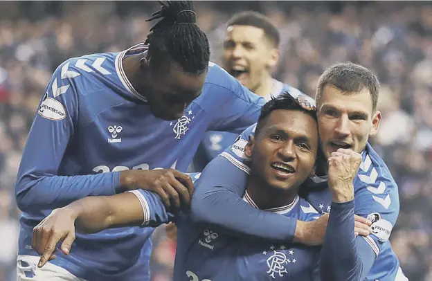  ??  ?? 0 Rangers’ Alfredo Morelos is mobbed by Joe Aribo, left, and Borna Barisic after opening the scoring in yesterday’s Ladbrokes Premiershi­p rout against Hearts at Ibrox.