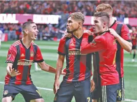  ?? AP PHOTO/CURTIS COMPTON ?? From left, Atlanta United FC players Miguel Almiron, Josef Martinez and Greg Garza celebrate after Martinez scored the first goal of Sunday’s 3-0 Eastern Conference final win against the New York Red Bulls at Mercedes-Benz Stadium.