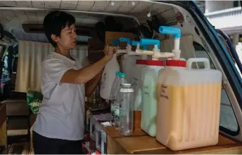  ?? ?? Oh pumps liquid detergent into an old laundry detergent bottle from inside her van at Sri Hartamas.