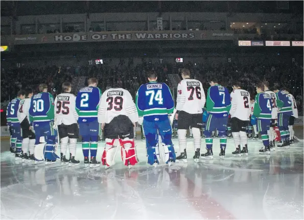  ??  ?? Players from the Moose Jaw Warriors and Swift Current Broncos form a circle at centre ice before Saturday night’s playoff game to mark the tragic crash of the Humboldt Broncos’ team bus.