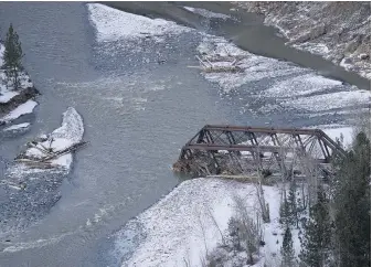  ?? JONATHAN HAYWARD, THE CANADIAN PRESS ?? A rail bridge washed out by flood waters near Merritt on Dec. 9. Economic growth in British Columbia has been hammered by floods and landslides that crippled transporta­tion, but the ability of government and industry to keep supply chains open limits the damage, an economist says.