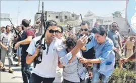  ?? REUTERS PHOTO ?? Police officers surround a man suspected to be involved in the attack on a beachside hotel in Sousse, Tunisia, on Friday. Authoritie­s later clarified that only one gunman was involved.