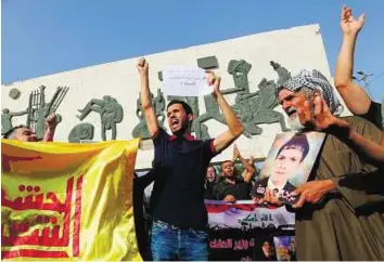  ?? AP ?? Protest against terror Protesters hold posters of missing Iraqi soldiers and chant slogans against Daesh during a protest at Tahrir Square in Baghdad.