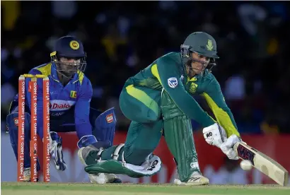  ?? AFP ?? South Africa’s Quinton de Kock plays a shot as Sri Lanka’s wicket-keeper Kusal Perera (left) looks on during the second ODI at the Rangiri Dambulla Internatio­nal Cricket Stadium in Dambulla on Wednesday. —