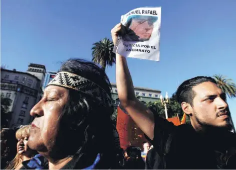  ??  ?? ► Activistas mapuches sostienen retratos de Rafael Nahuel, en Buenos Aires, el domingo.