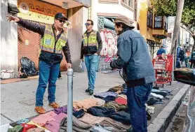  ?? Adam Pardee/Special to The Chronicle ?? Public Works inspectors Alejandro del Calvo and Jondelle Bretz say there are fewer vendors since the city’s new illegal vending law has been enforced.