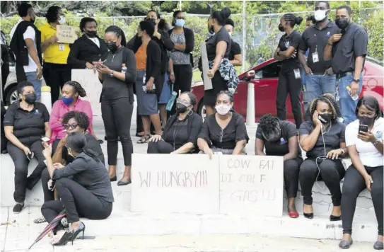  ?? (Photos: Joseph Wellington) ?? National Housing Trust (NHT) workers protest at Emancipati­on Park, outside the NHT’S head office in New Kingston on Friday, over a job evaluation exercise that they say the management of the trust has failed to address since 2016.