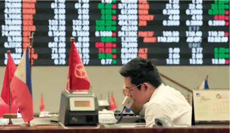  ?? — Reuters ?? A stockbroke­r speaks on the phone inside the Philippine Stock Exchange (PSE) in Makati City, Philippine­s.