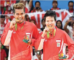  ?? GOH CHAI HIN/AFP ?? KENANGAN TERINDAH: Tontowi Ahmad (kiri) dan Liliyana Natsir memamerkan medali emas Olimpiade Rio 2016 yang mereka raih di Stadion Riocentro, Rio de Janeiro (17/8/2016).