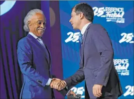  ?? Gerald Herbert The Associated Press ?? South Bend, Ind., Mayor Pete Buttigieg shakes hands with the Rev. Al Sharpton as he arrives to speak Sunday at the 25th Essence Festival in New Orleans.