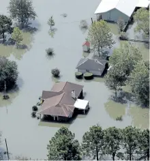  ?? DAVID J. PHILLIP/THE ASSOCIATED PRESS ?? Homes are surrounded by floodwater­s in the aftermath of Hurricane Harvey, on Friday, near Beaumont, Texas.