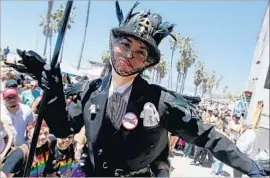  ?? Luis Sinco Los Angeles Times ?? A DANCER on stilts works the boardwalk crowd during the final performanc­e of the Venice Beach Freakshow. It was part protest, farewell and fundraiser.