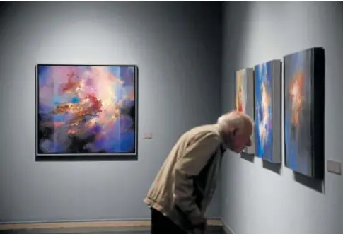  ?? // VALERIO MERINO ?? Un hombre observa de cerca una de las obras abstractas de Antonio Bujalance en la Sala Vimcorsa