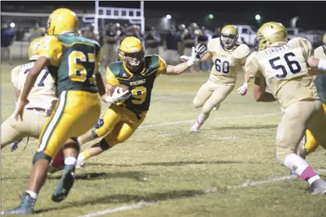  ??  ?? Andy Pascual runs in between defenders as he inches closer to the end zone. EDWIN DELGADO PHOTO