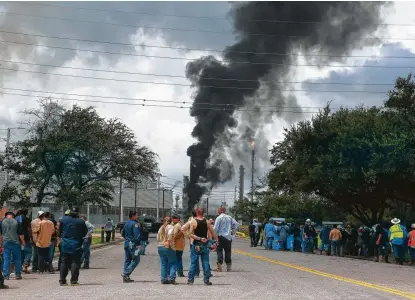  ?? Yi-Chin Lee / Staff photograph­er ?? Exxon Mobil workers evacuate outside the Olefins plant in Baytown on Wednesday after an explosion started a fire.