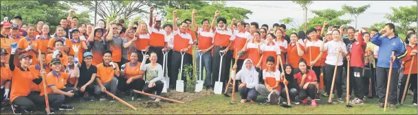  ??  ?? Lee (standing tenth left) with MRC Miri chapter members during the mass tree planting ceremony yesterday.