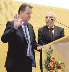  ??  ?? Klaus Schellenbe­rg (links) leistet im Beisein seines Stellvertr­eters Harald Schmid (rechts) den Eid.