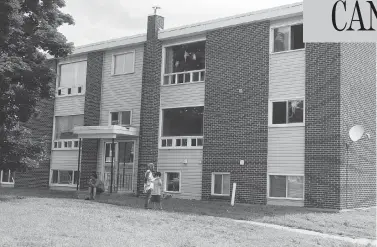  ?? STEPHEN MACGILLIVR­AY / THE CANADIAN PRESS ?? A family gathers outside of a Fredericto­n apartment building complex where four people were killed, including two police officers, in a shooting last Friday. Police removed barricades and allowed residents to return on Tuesday.