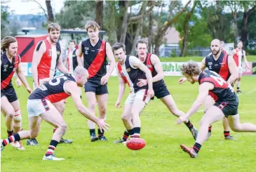  ??  ?? Nyora’s Rhys Bancroft and Nilma-Darnum’s Andrew Campbell have eyes on the ball as the pack watch the outcome.