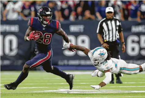  ?? Tim Warner / Getty Images ?? Alfred Blue (izq.), corredor de los Texans, elude a Bobby McCain, de los Dolphins de Miami, en el partido del jueves 25 de octubre de 2018 en el NRG Stadium de Houston.