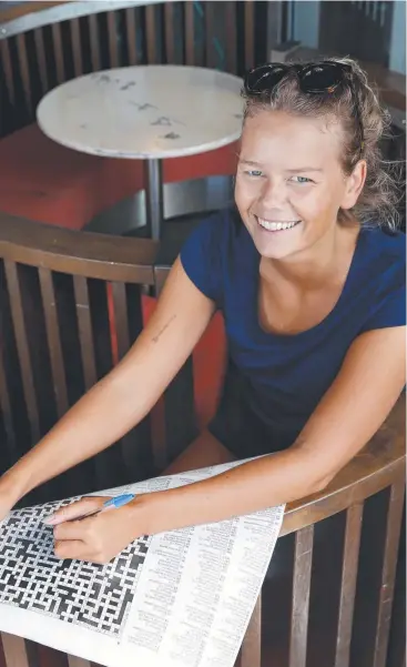 ?? Picture: ANNA ROGERS ?? WORDSMITH: Cecilie Christanse­n checks out the highly popular Mega crossword puzzle, available to readers in the Weekend Post.