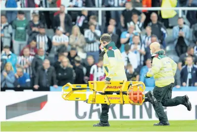  ?? AP ?? LEFT: Medics run with a stretcher to treat a spectator struck with a medical emergency in the crowd at St James’ Park yesterday.