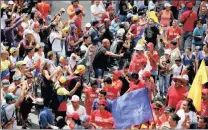  ??  ?? Supporters of Venezuela’s President Nicolas Maduro, clad in red, and opposition supporters argue in Caracas.