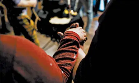  ?? ARMANDO L. SANCHEZ/CHICAGO TRIBUNE PHOTOS ?? Participan­ts hold hands during a full moon ritual at Malliway Bros. Spells, Charms & Potions in Chicago.