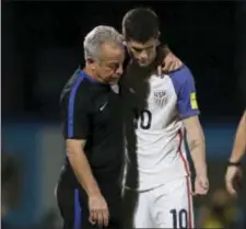  ?? REBECCA BLACKWELL — THE ASSOCIATED PRESS ?? United States’ Christian Pulisic, right, is comforted by a member of the team staff after the U.S. lost to Trinidad and Tobago on Tuesday.
