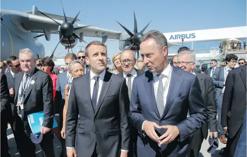  ?? MICHEL EULER, POOL / THE ASSOCIATED PRESS ?? French President Emmanuel Macron, left, visits the Paris Air Show Monday in Le Bourget, north of Paris, with the CEO of Airbus, Fabrice Brégier, right, after landing in an Airbus A400-M military transport, seen behind the two.