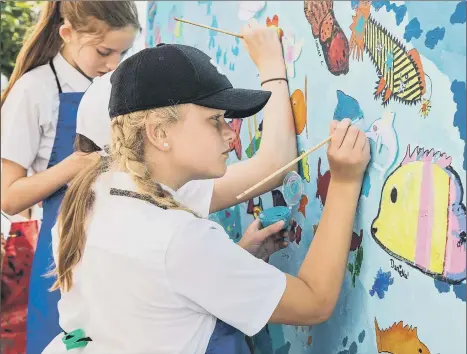  ?? Picture: Mike Cooter (200721) ?? SPLASH OF COLOUR Evie, 11, from Solent Road School Juniors painting a dolphin on the wall at Hilsea Lido.