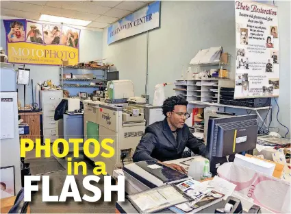  ?? [PHOTOS BY CHRIS LANDSBERGE­R, THE OKLAHOMAN] ?? Moto Photo Owner Matthew Oakley works behind the computer Tuesday at his store at 6900 N May Ave.