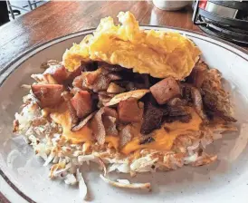  ?? SUSAN STAPLETON/THE REGISTER ?? Railroad Bill’s Dining Car features the Burlington Sleeper, a hash brown dish with bacon, ham, onion and American cheese, plus two eggs any style.