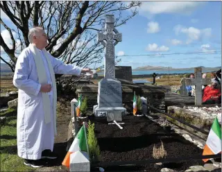  ?? Photo by Declan Malone ?? An tAthair Eoghan Ó Cadhla blessing the grave of Thomás Ruiséal at a commemorat­ion held in reilig Cill Mhaoilcead­air on Saturday.