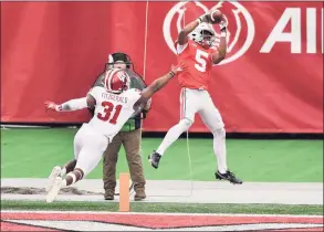  ?? Jamie Sabau / TNS ?? Ohio State’s Garrett Wilson catches a 9-yard pass in the end zone as Indiana’s Bryant Fitzgerald defends in the third quarter on Saturday at Ohio Stadium in Columbus, Ohio. Ohio State defeated Indiana 42-35.