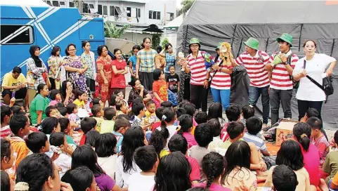  ?? KEMDIKBUD FOR JAWA POS ?? DONGENG BONEKA: Relawan dari forum asosiasi kursus dan pelatihan sedang menghibur anak-anak korban bencana banjir di Jalan Raya Kalibata Jakarta.
