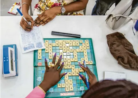  ?? Fotos: Christian Putsch ?? In Nigeria ist Scrabble Volkssport. Und damit ist nicht die Fähigkeit gemeint, mit solchen Fingernäge­ln Wörter wie „phobias“(Phobien) oder „duty“(Pflicht) zu legen. Ein Turnier am Rande der Millionens­tadt Lagos.