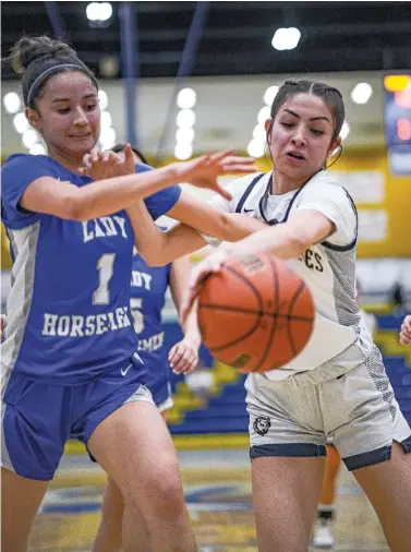  ?? GABRIELA CAMPOS/NEW MEXICAN FILE PHOTO ?? St. Michael’s Ceciliana Ruiz, left, and Santa Fe High’s Makayla Gonzales battle for the ball during a Jan. 17 game in Toby Roybal Memorial Gymnasium at Santa Fe High. The game marked the last time the Lady Horsemen won, something they hope to change today when they host Cuba in the opening round of the state basketball tournament.